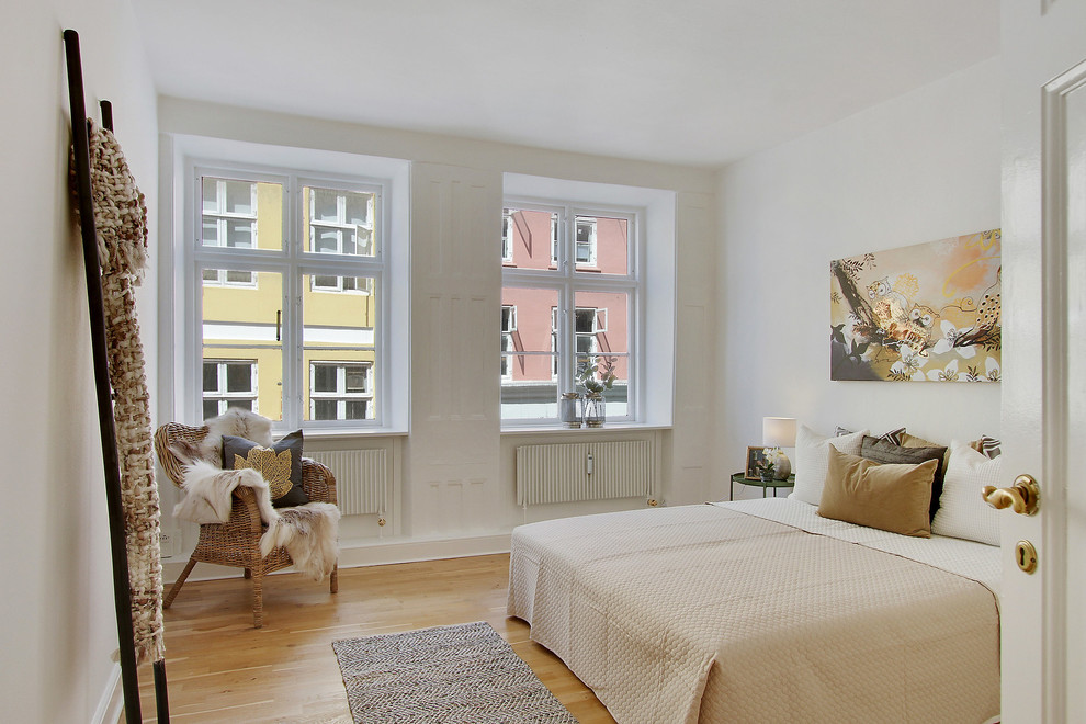Photo of a scandinavian guest bedroom in Copenhagen with white walls, light hardwood floors and beige floor.