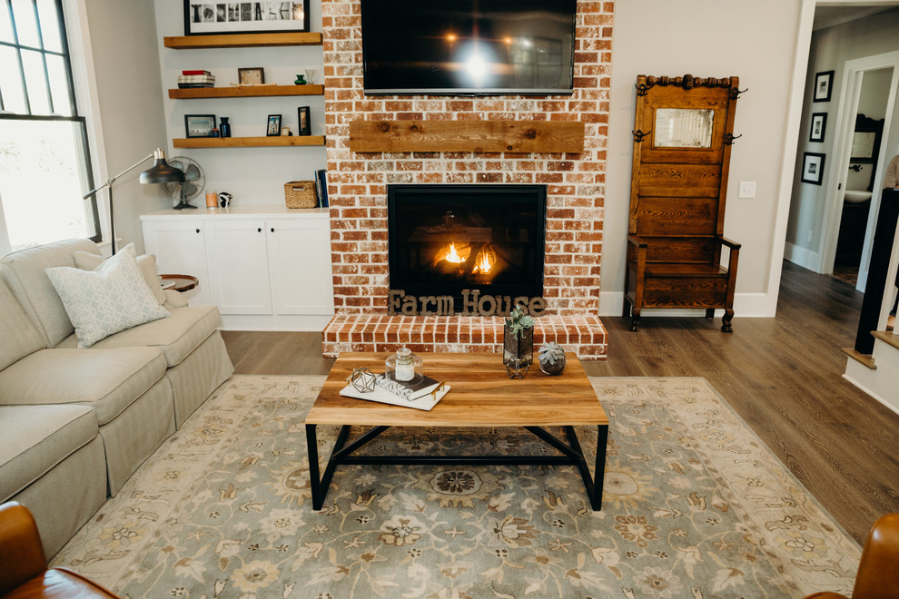 Mid-sized country open concept family room in Atlanta with brown walls, medium hardwood floors, a standard fireplace, a brick fireplace surround, a wall-mounted tv and brown floor.