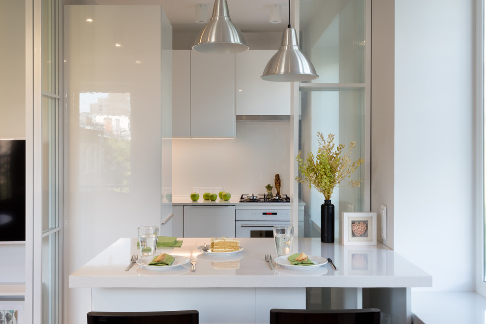 This is an example of a scandinavian l-shaped open plan kitchen in Moscow with flat-panel cabinets, white cabinets, white splashback and with island.
