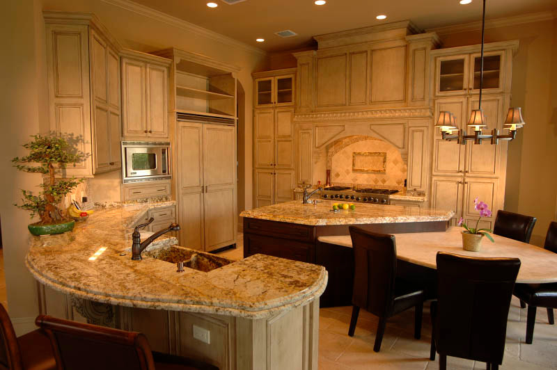 Inspiration for a large transitional eat-in kitchen remodel in Indianapolis with a double-bowl sink, raised-panel cabinets, light wood cabinets, granite countertops, beige backsplash, stainless steel appliances and an island