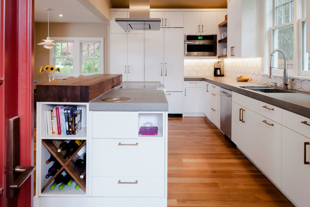 Design ideas for a mid-sized scandinavian l-shaped eat-in kitchen in Other with an undermount sink, flat-panel cabinets, white cabinets, concrete benchtops, white splashback, ceramic splashback, panelled appliances, medium hardwood floors, with island, brown floor and grey benchtop.