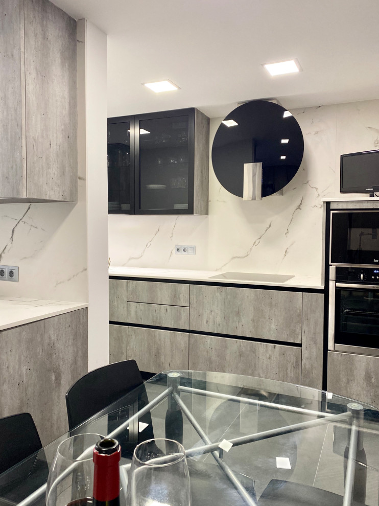 Photo of a large industrial l-shaped separate kitchen in Barcelona with a single-bowl sink, flat-panel cabinets, grey cabinets, granite benchtops, white splashback, stainless steel appliances, ceramic floors, grey floor and white benchtop.