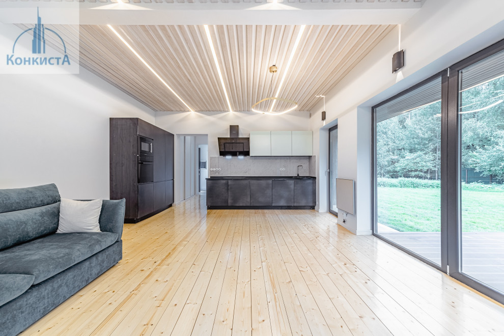Esempio di un grande soggiorno design stile loft con pareti grigie, pavimento in legno verniciato e soffitto in perlinato