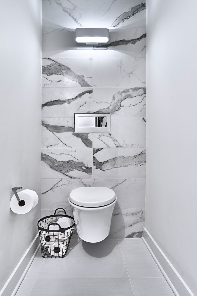 Photo of an expansive modern powder room in Chicago with flat-panel cabinets, a one-piece toilet, white tile, porcelain tile, white walls, porcelain floors, an undermount sink, engineered quartz benchtops, white benchtops, grey cabinets and white floor.