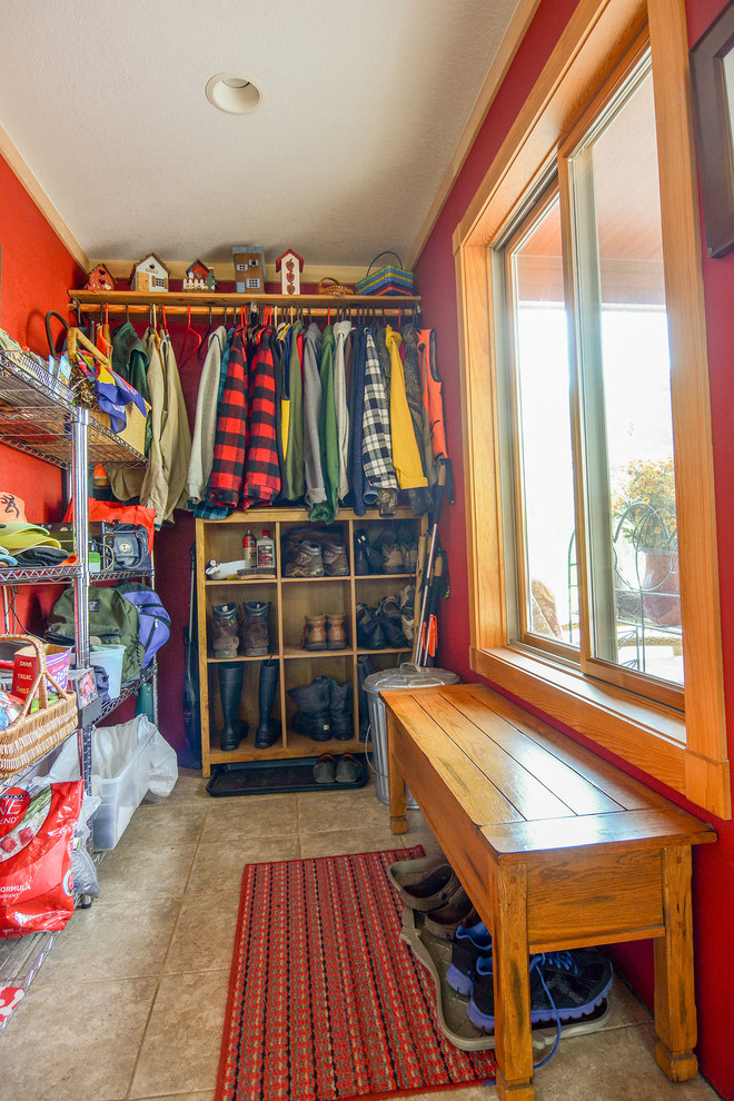 Photo of a mid-sized country mudroom in Other with red walls, ceramic floors, a single front door and a glass front door.