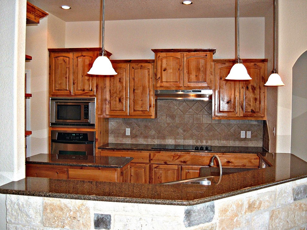 Eat-in kitchen - mid-sized rustic u-shaped eat-in kitchen idea with a drop-in sink, raised-panel cabinets, medium tone wood cabinets, granite countertops, ceramic backsplash, stainless steel appliances, an island, brown backsplash and brown countertops