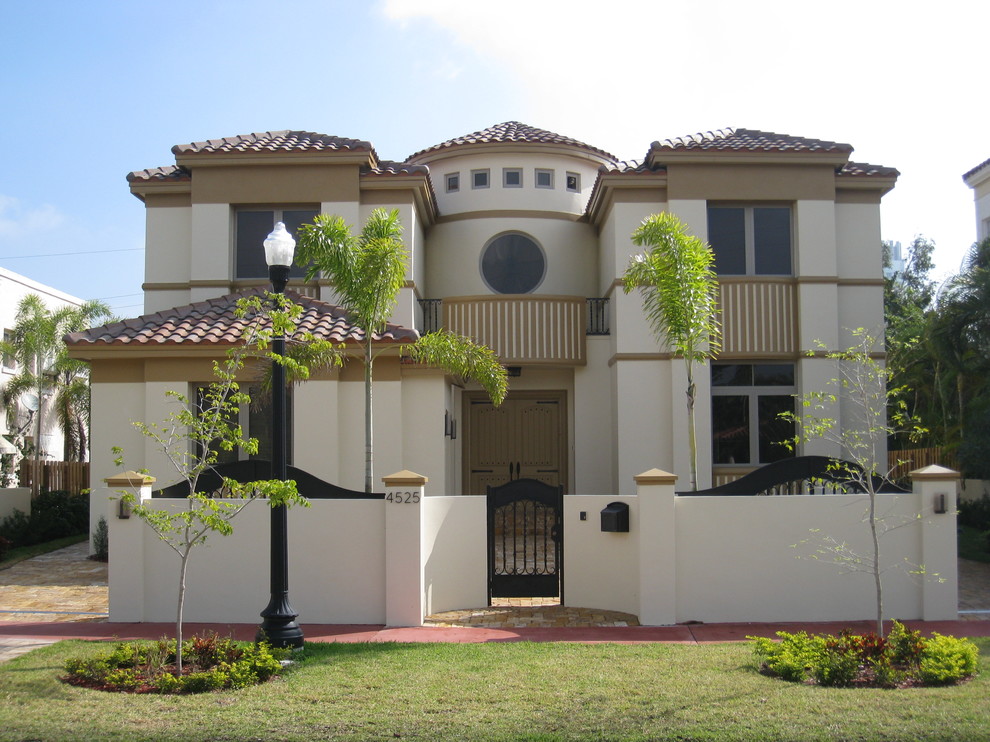 Design ideas for a mediterranean two-storey stucco beige exterior in Miami.