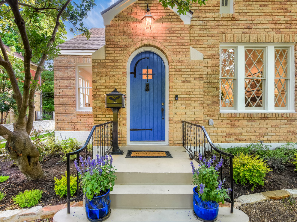 This is an example of an expansive transitional front door in Austin with a single front door, a blue front door and grey floor.