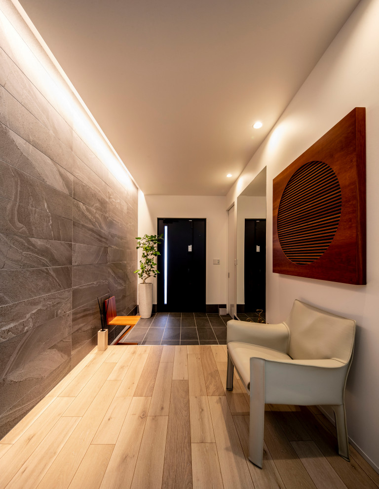 Ispirazione per un corridoio minimalista con pareti grigie, parquet chiaro, una porta singola, una porta nera, pavimento beige e soffitto in carta da parati