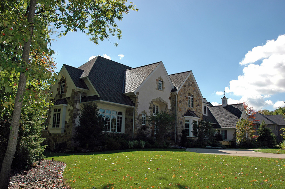 This is an example of a large traditional two-storey beige exterior in Cleveland with stone veneer.