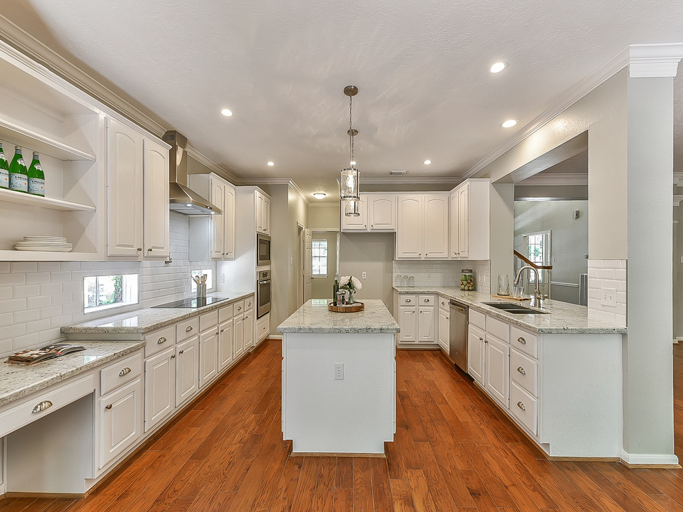Mid-sized transitional u-shaped medium tone wood floor and orange floor eat-in kitchen photo in Houston with an undermount sink, louvered cabinets, white cabinets, granite countertops, white backsplash, subway tile backsplash, stainless steel appliances, an island and white countertops