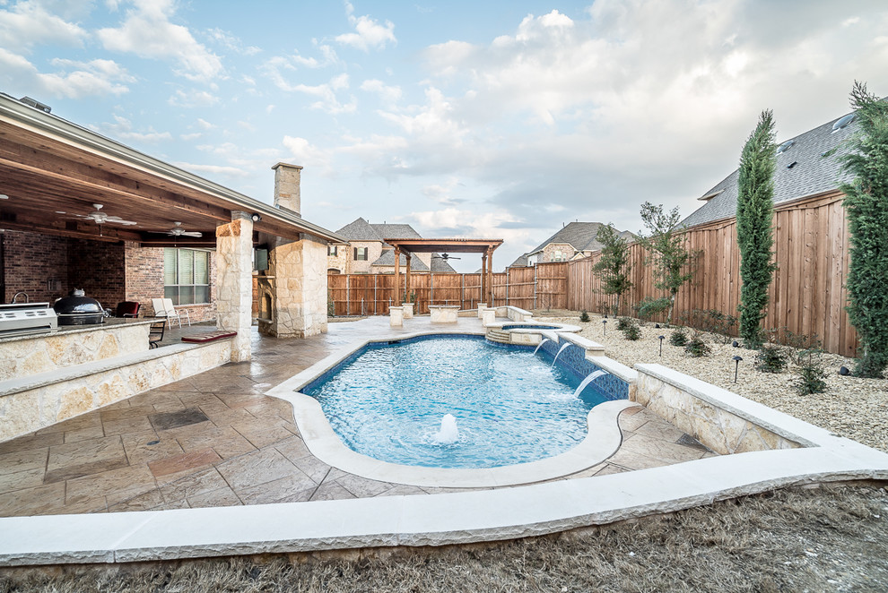 This is an example of a large mediterranean backyard custom-shaped natural pool in Dallas with a water feature and stamped concrete.
