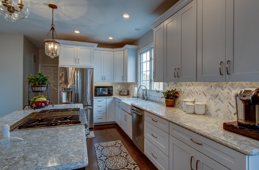 Eat-in kitchen - mid-sized transitional u-shaped dark wood floor and brown floor eat-in kitchen idea in DC Metro with a farmhouse sink, shaker cabinets, white cabinets, stainless steel appliances, an island, gray countertops, quartzite countertops, white backsplash and mosaic tile backsplash