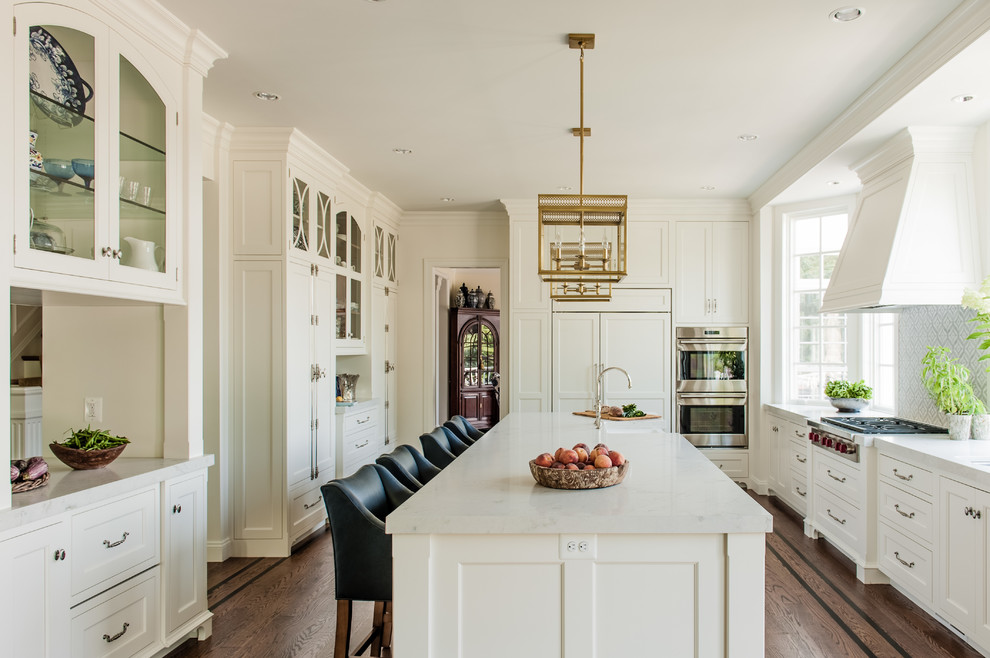 Inspiration for a large traditional separate kitchen in Philadelphia with a farmhouse sink, white cabinets, marble benchtops, multi-coloured splashback, marble splashback, panelled appliances, dark hardwood floors, with island, white benchtop and shaker cabinets.