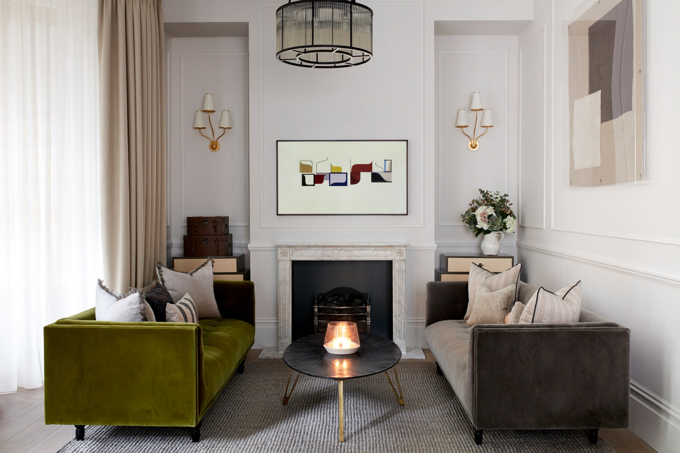 This is an example of a transitional living room in London with white walls, dark hardwood floors, a standard fireplace and brown floor.