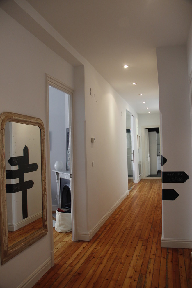Imagen de recibidores y pasillos clásicos renovados de tamaño medio con paredes blancas y suelo de madera clara