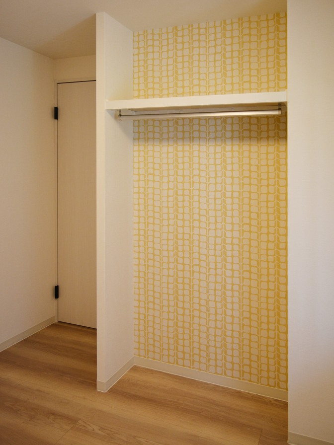 Modelo de armario escandinavo con armarios con paneles lisos, puertas de armario de madera clara, suelo de contrachapado y suelo beige