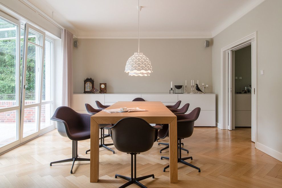 Photo of a mid-sized contemporary separate dining room in Hamburg with grey walls and light hardwood floors.