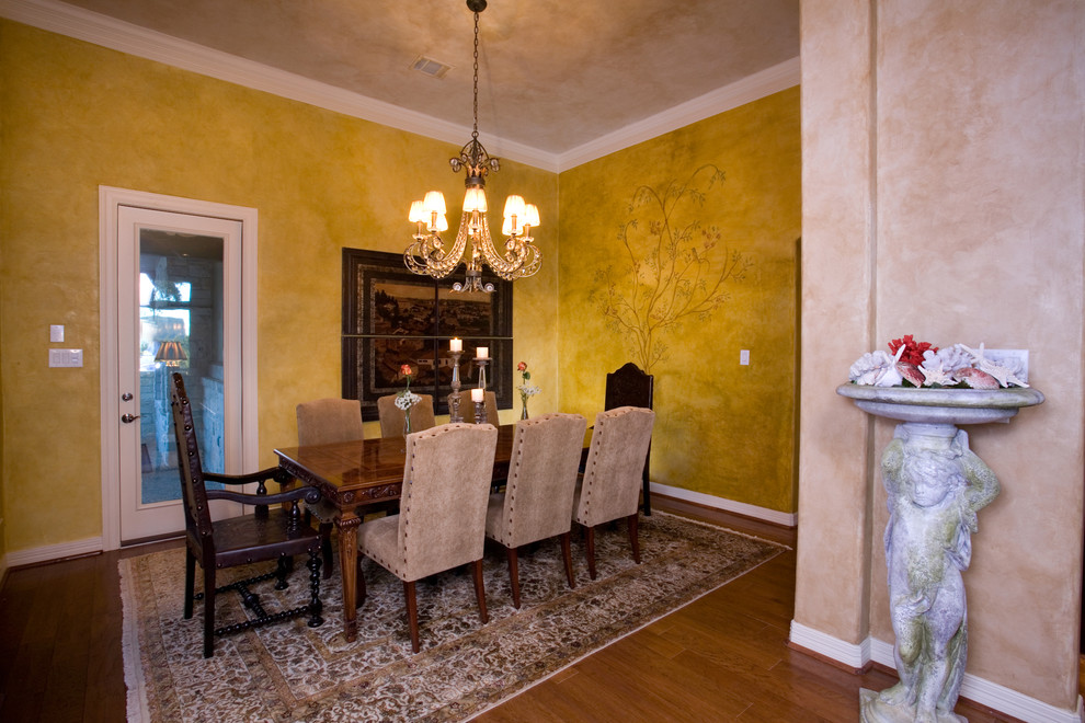 Mid-sized mediterranean dining room in Austin with multi-coloured walls and medium hardwood floors.