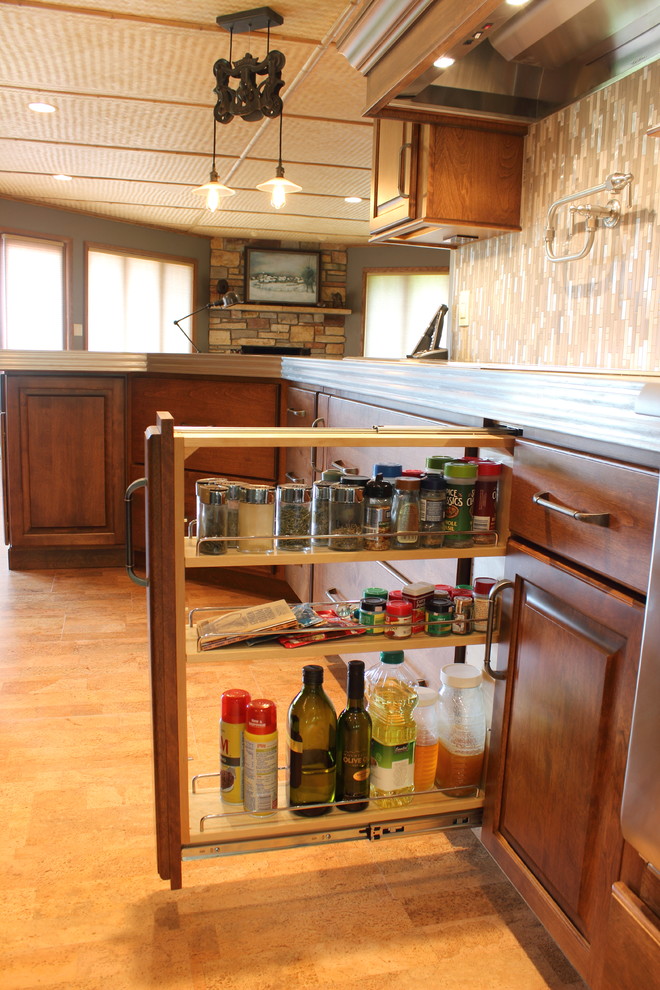 Large transitional cork floor home design photo with raised-panel cabinets, medium tone wood cabinets, glass tile backsplash and an island