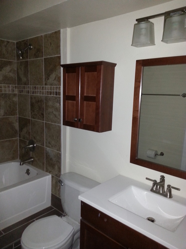 Inspiration for a mid-sized transitional 3/4 porcelain tile and brown floor alcove bathtub remodel with furniture-like cabinets, dark wood cabinets, a two-piece toilet, white walls, an integrated sink, quartz countertops and white countertops