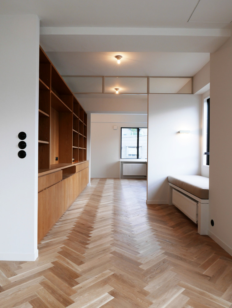 Midcentury home office in Tokyo with white walls, light hardwood floors and beige floor.