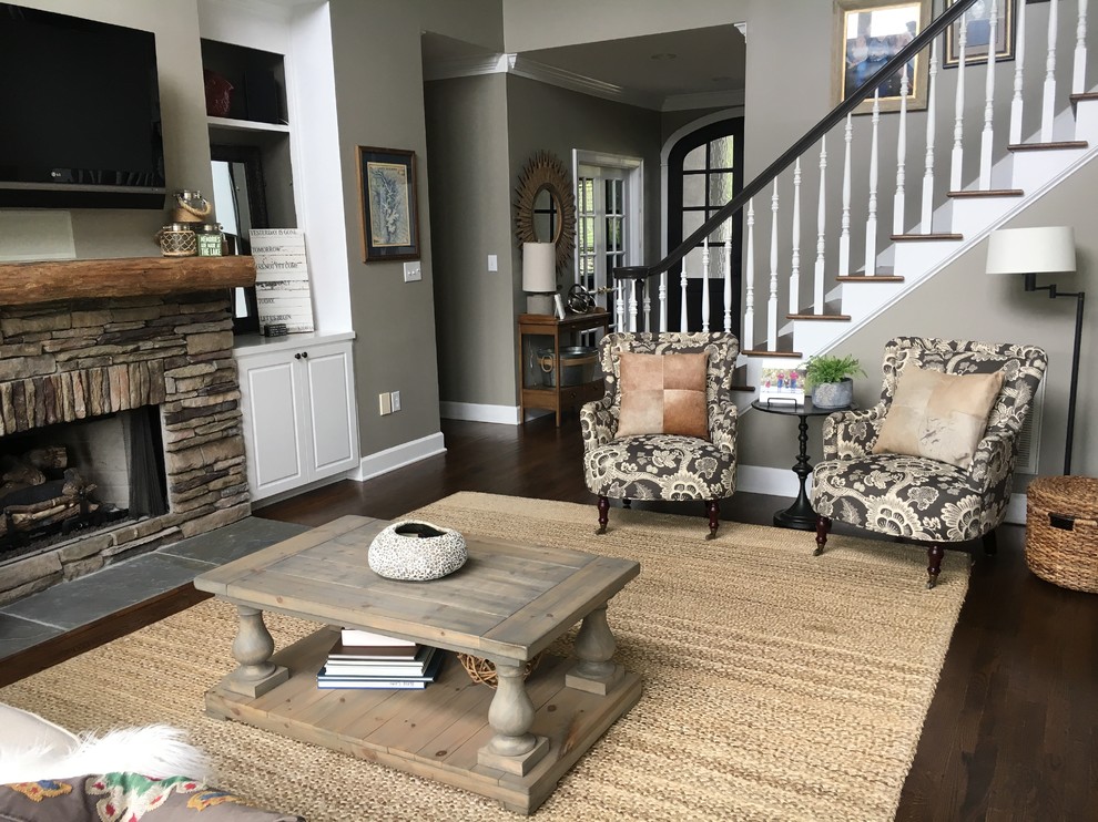 Inspiration for a mid-sized country open concept living room in Charlotte with dark hardwood floors, a stone fireplace surround, a wall-mounted tv, grey walls, a standard fireplace and brown floor.