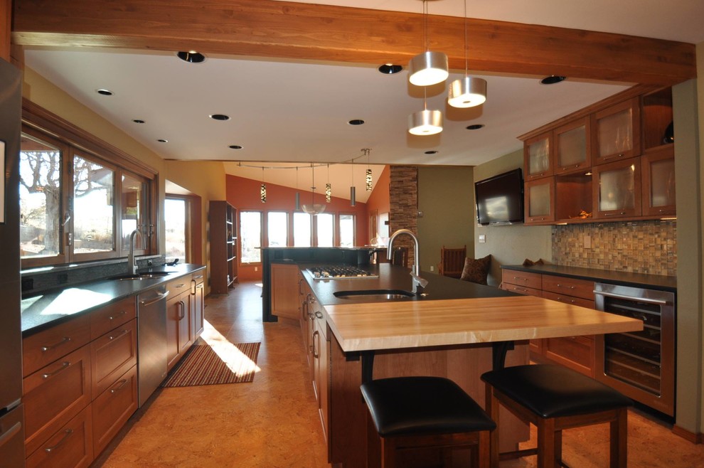 Inspiration for a large rustic u-shaped eat-in kitchen remodel in Boise with a double-bowl sink, glass-front cabinets, light wood cabinets, soapstone countertops, matchstick tile backsplash, stainless steel appliances and two islands