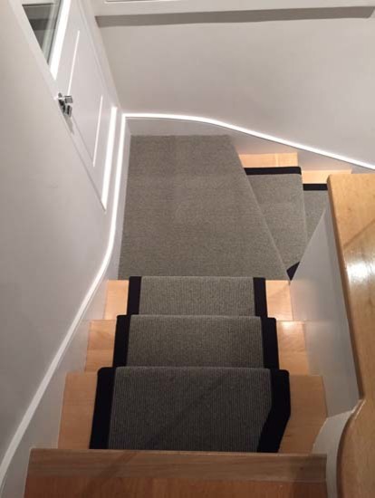 Mid-sized transitional carpeted u-shaped staircase in London with carpet risers and mixed railing.