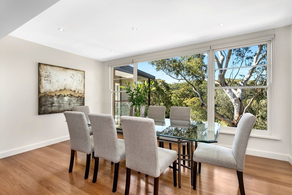 Transitional separate dining room in Sydney with beige walls, medium hardwood floors and brown floor.