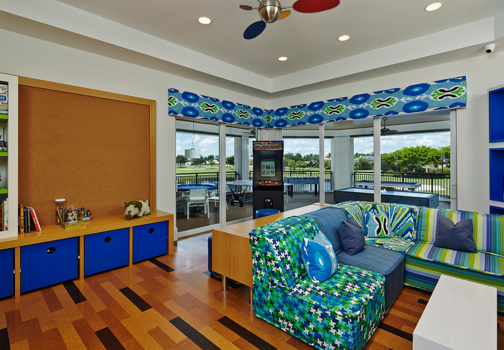 This is an example of an expansive contemporary kids' playroom for kids 4-10 years old and boys in Miami with white walls and medium hardwood floors.