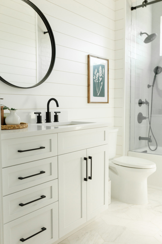 Example of a mid-sized beach style gray tile and ceramic tile porcelain tile, multicolored floor, single-sink and shiplap wall bathroom design in Miami with shaker cabinets, white cabinets, white walls, a drop-in sink, quartz countertops, white countertops and a built-in vanity