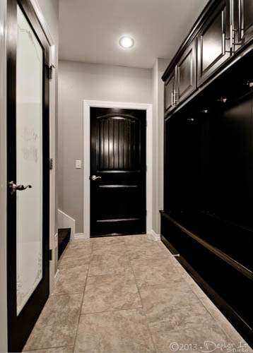 Elegant ceramic tile laundry room photo in Other with raised-panel cabinets, dark wood cabinets and gray walls