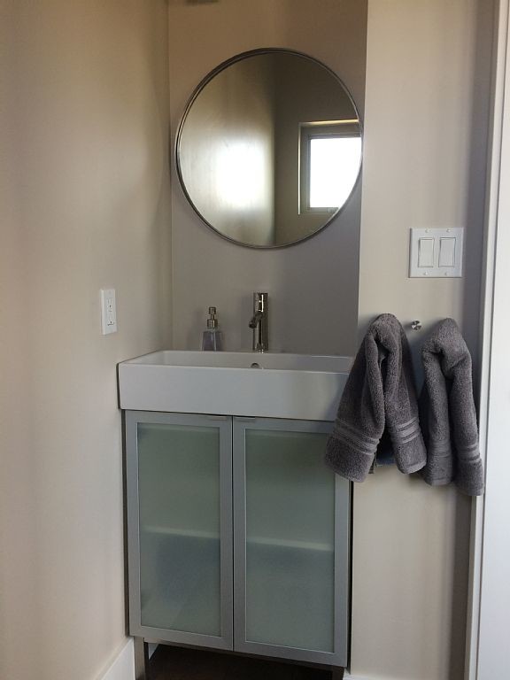 Design ideas for a small industrial master bathroom in Denver with a vessel sink, glass-front cabinets, grey cabinets, beige walls and medium hardwood floors.