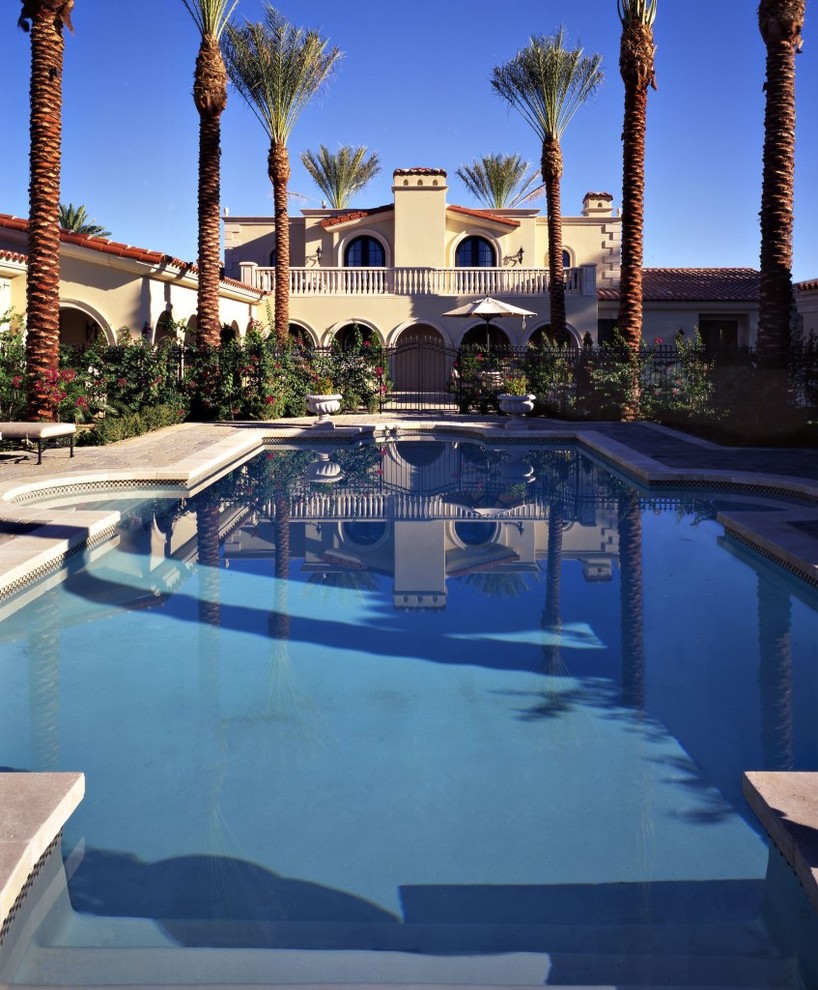 Expansive traditional backyard custom-shaped pool in Phoenix with a water feature and concrete slab.