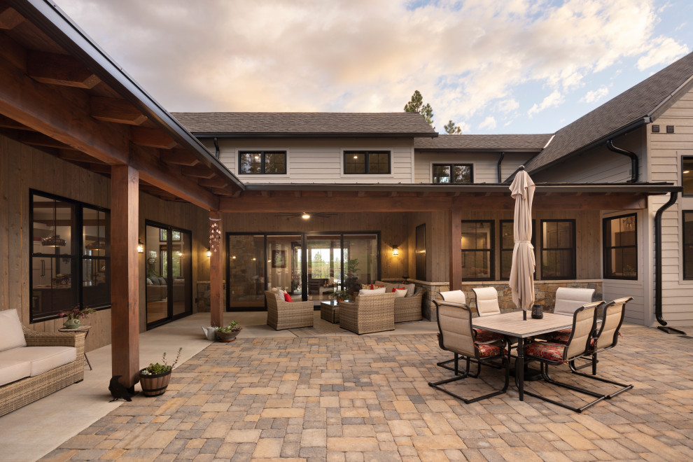 Design ideas for a mid-sized country courtyard patio in Denver with brick pavers.