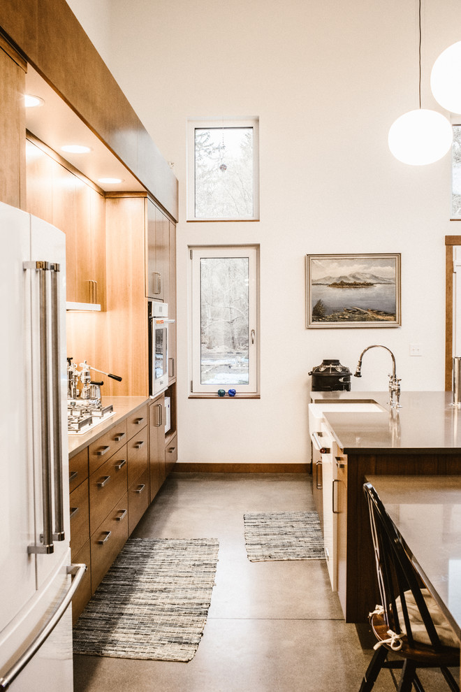 This is an example of a mid-sized contemporary single-wall open plan kitchen in Seattle with a farmhouse sink, flat-panel cabinets, dark wood cabinets, quartzite benchtops, multi-coloured splashback, ceramic splashback, white appliances, concrete floors, with island, grey floor and grey benchtop.