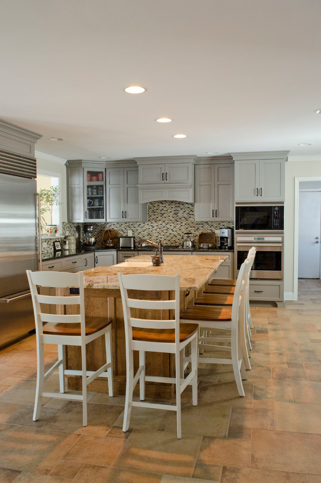 Photo of a large transitional u-shaped eat-in kitchen in Philadelphia with mosaic tile splashback, stainless steel appliances, a farmhouse sink, shaker cabinets, grey cabinets, multi-coloured splashback, granite benchtops, porcelain floors and with island.