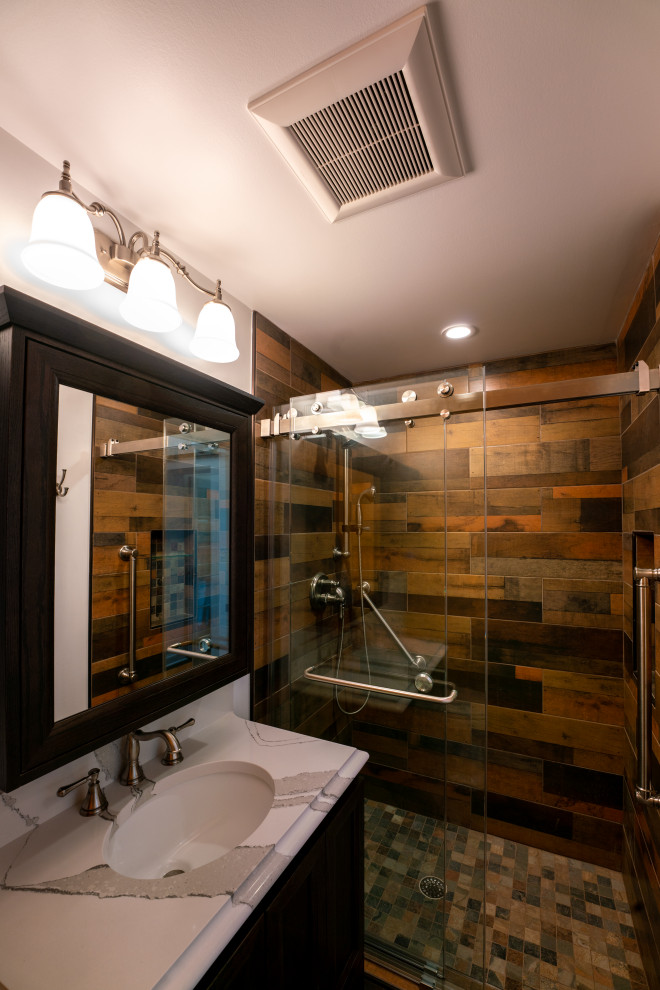 Mid-sized arts and crafts 3/4 bathroom in DC Metro with brown cabinets, brown tile, wood-look tile, white walls, dark hardwood floors, marble benchtops, brown floor, a sliding shower screen, white benchtops, a single vanity and a built-in vanity.