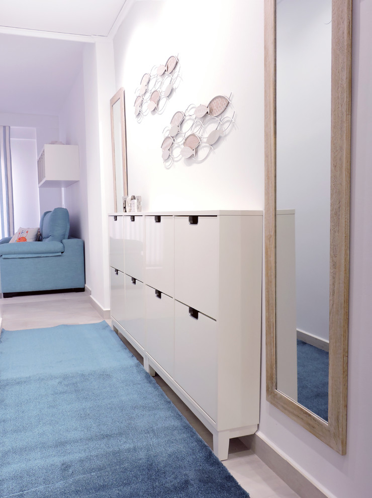 This is an example of a small beach style hallway in Valencia with white walls, ceramic floors and beige floor.