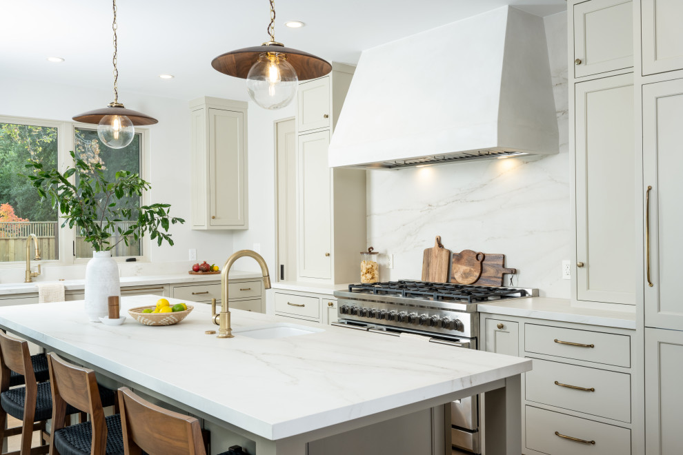 Large traditional galley open plan kitchen in San Francisco with an undermount sink, beaded inset cabinets, beige cabinets, quartz benchtops, white splashback, engineered quartz splashback, panelled appliances, light hardwood floors, with island, brown floor, white benchtop and exposed beam.