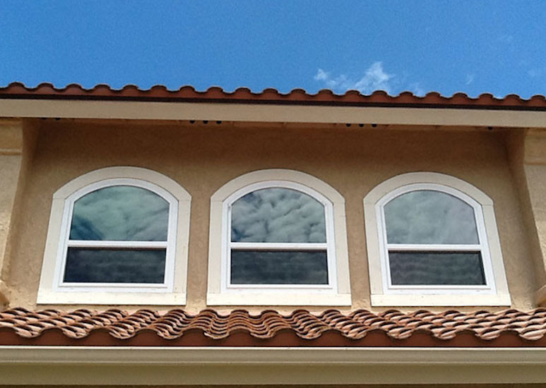 Mid-sized traditional two-storey stucco beige house exterior in Orange County with a gable roof and a tile roof.