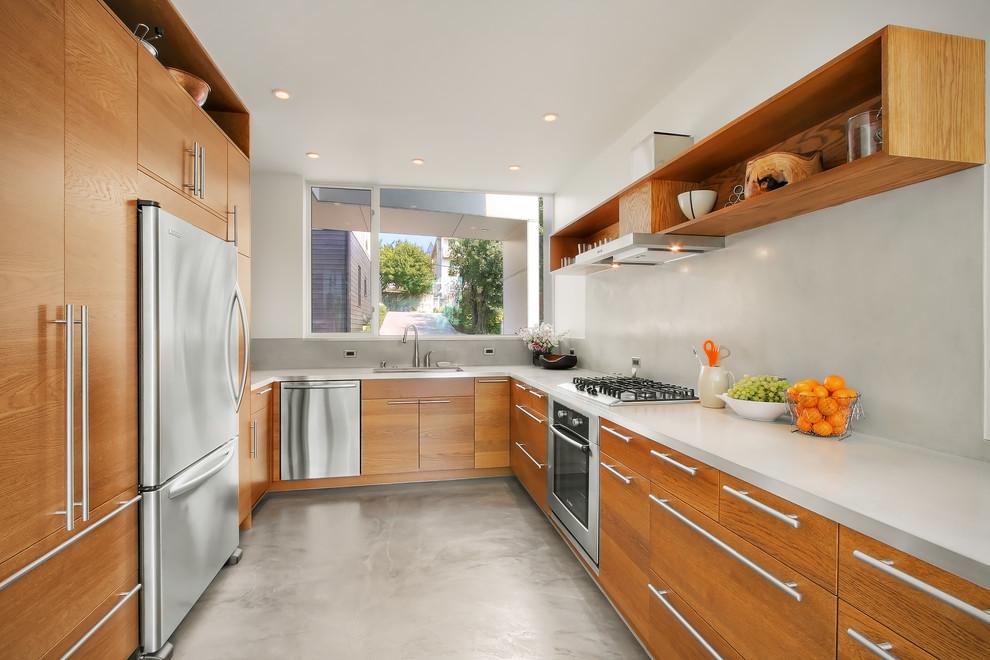 Photo of a mid-sized modern u-shaped kitchen in Seattle with flat-panel cabinets, medium wood cabinets, stainless steel appliances, concrete floors and no island.