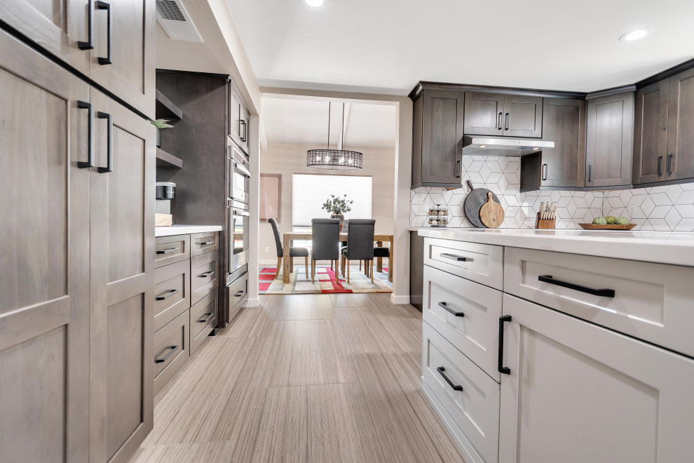 Large transitional u-shaped eat-in kitchen in Phoenix with an undermount sink, shaker cabinets, dark wood cabinets, quartzite benchtops, white splashback, porcelain splashback, stainless steel appliances, porcelain floors, with island, multi-coloured floor and white benchtop.