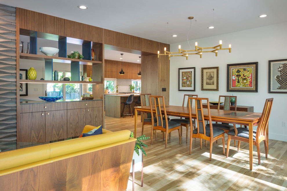 Photo of a midcentury open plan dining in Kansas City with white walls and light hardwood floors.