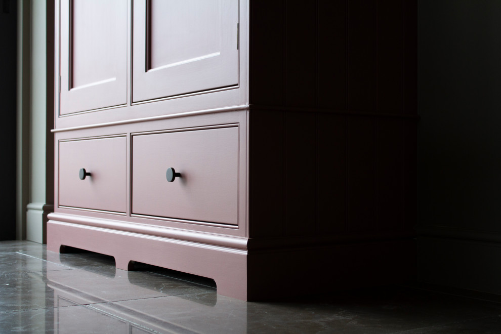 Design ideas for a mid-sized traditional l-shaped separate kitchen in Surrey with a farmhouse sink, beaded inset cabinets, pink cabinets, marble benchtops, marble splashback, black appliances, limestone floors, with island, grey floor and grey benchtop.