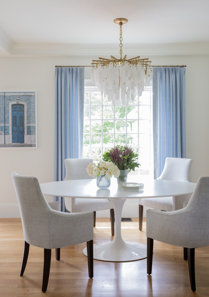 Inspiration for a medium sized classic dining room in Boston with banquette seating, white walls and medium hardwood flooring.