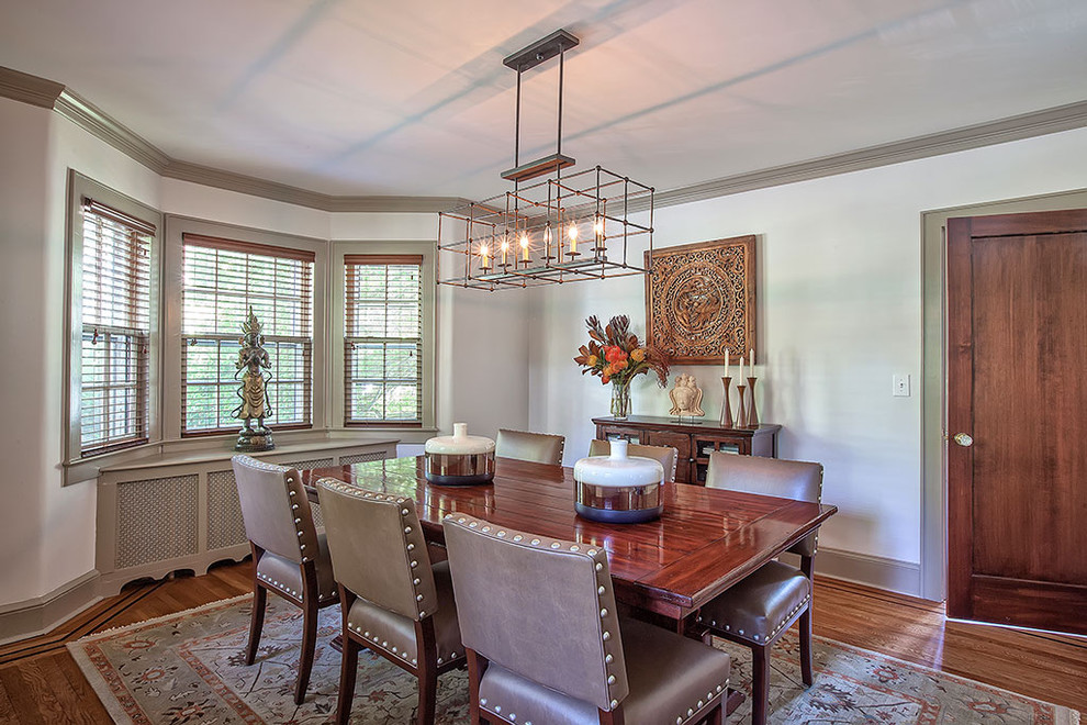 Photo of a mid-sized contemporary dining room in New York with white walls and medium hardwood floors.