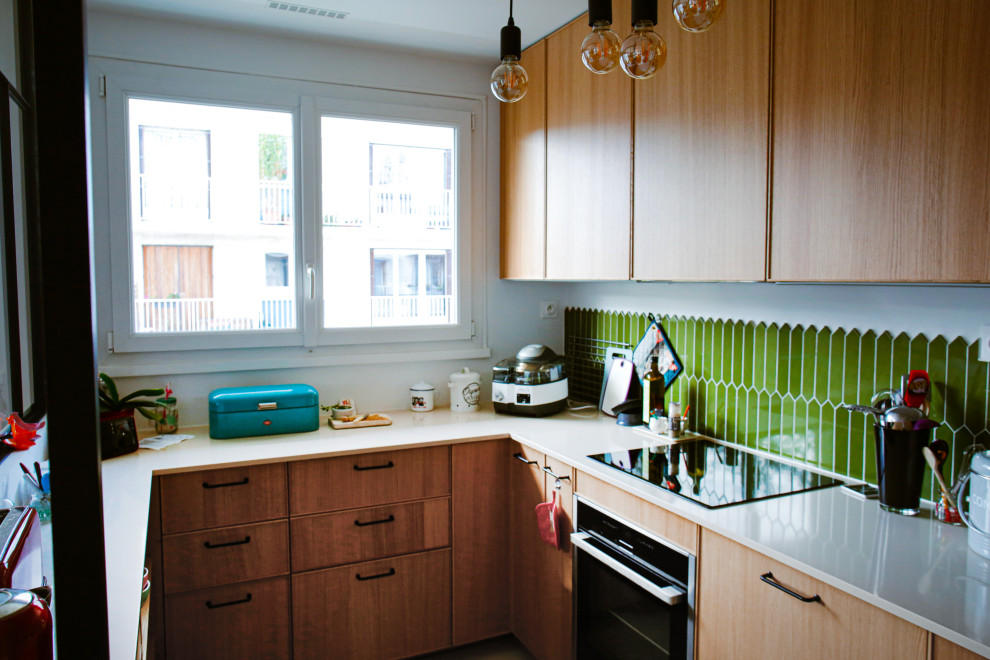パリにある高級な広いコンテンポラリースタイルのおしゃれなキッチン (アンダーカウンターシンク、インセット扉のキャビネット、淡色木目調キャビネット、大理石カウンター、緑のキッチンパネル、ガラスタイルのキッチンパネル、パネルと同色の調理設備、ベージュの床、白いキッチンカウンター) の写真