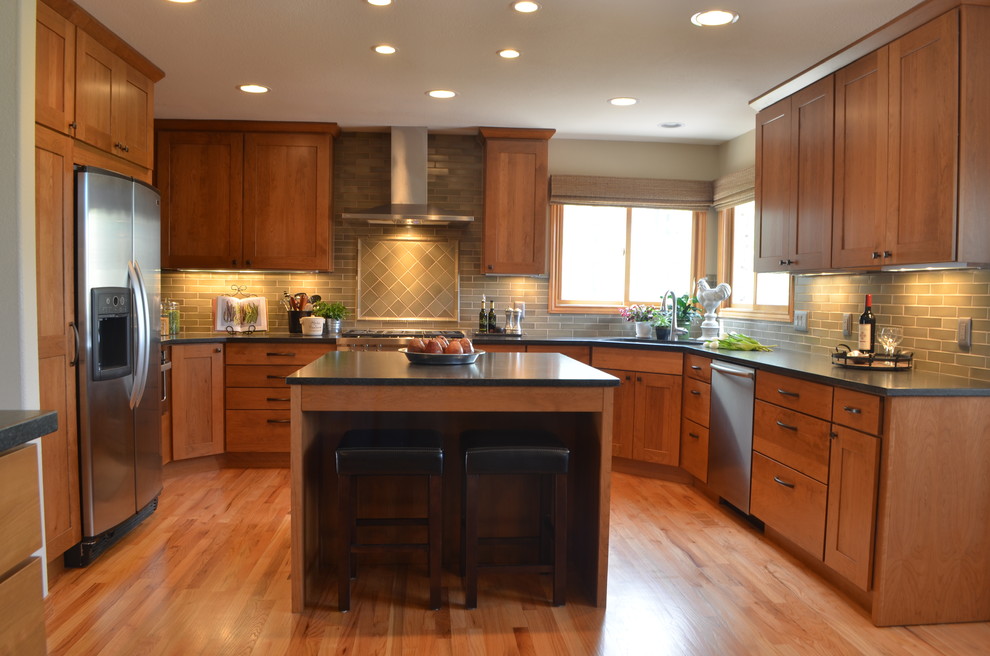 Eat-in kitchen - mid-sized transitional u-shaped light wood floor eat-in kitchen idea in Denver with a single-bowl sink, shaker cabinets, medium tone wood cabinets, granite countertops, green backsplash, ceramic backsplash, stainless steel appliances and an island